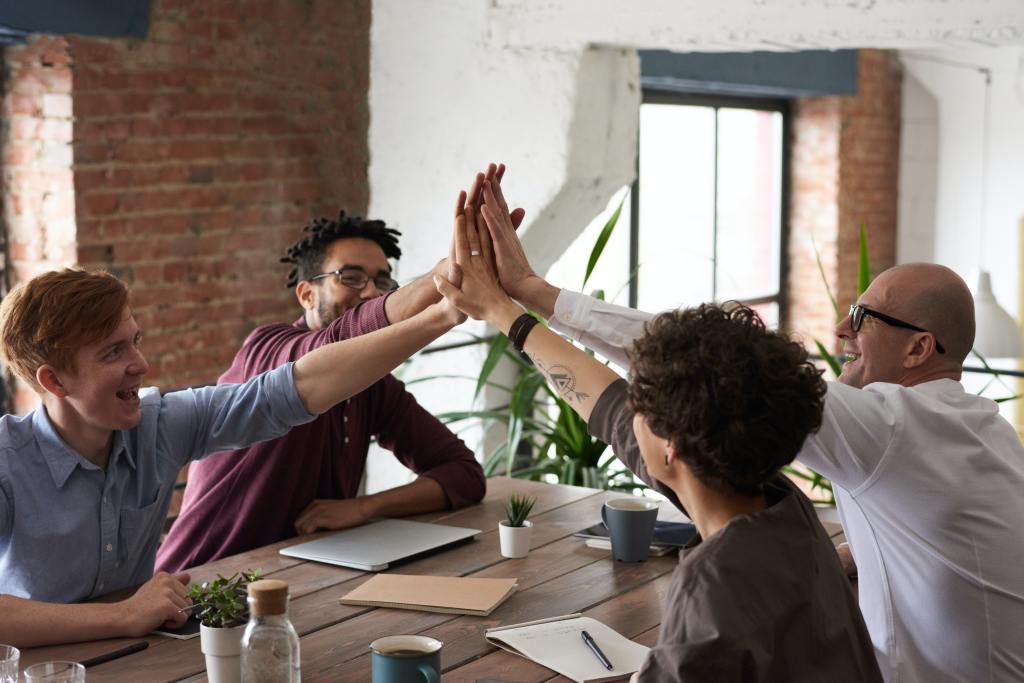 A group of coworkers high-five.